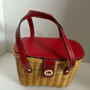 Red lid, straps, gold tone details, and wicker base.